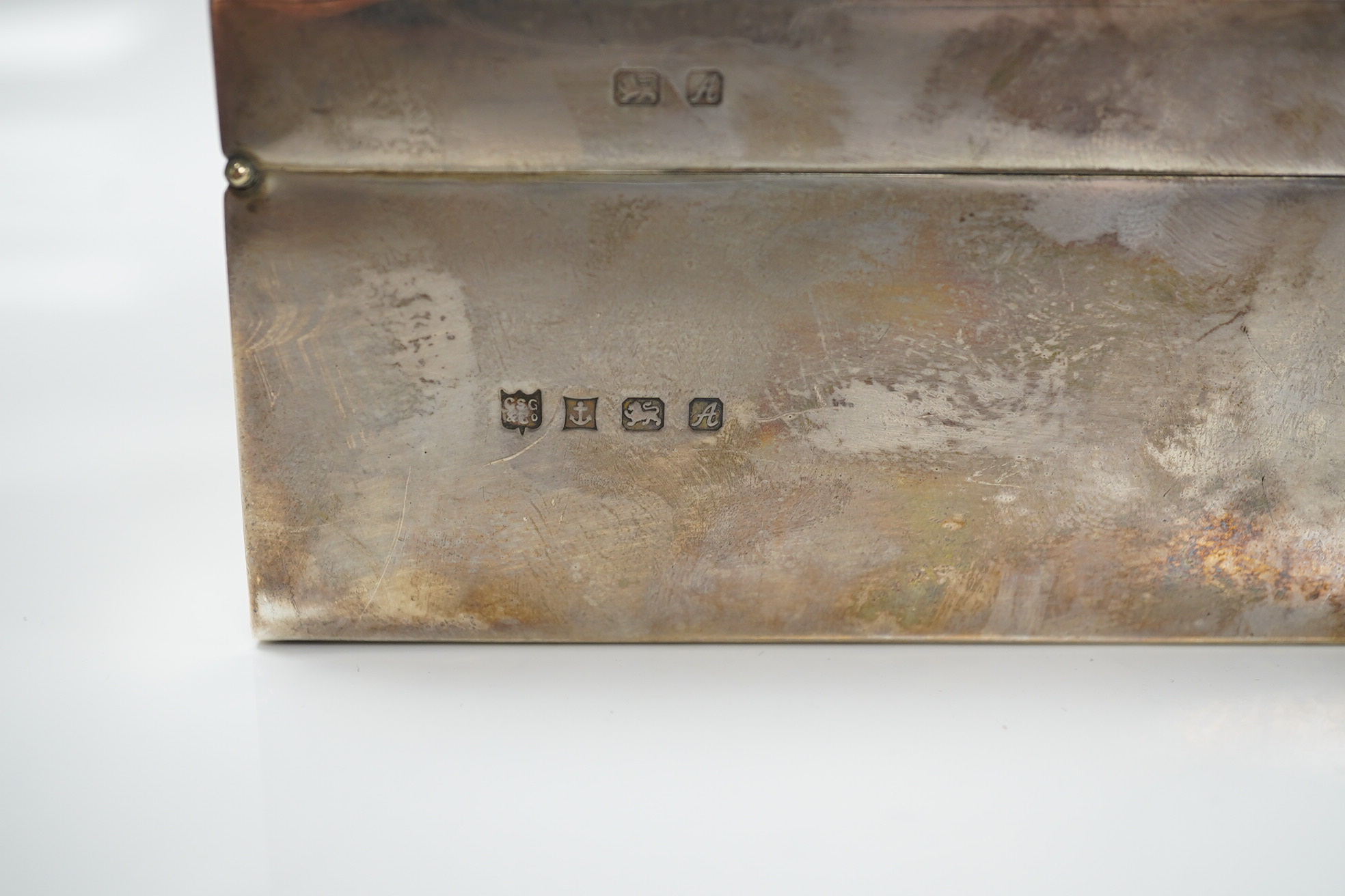 An Elizabeth II silver mounted rectangular cigarette box, with engraved inscription, C.S. Green & Co, Birmingham, 1975, 16.4cm. Condition - poor to fair